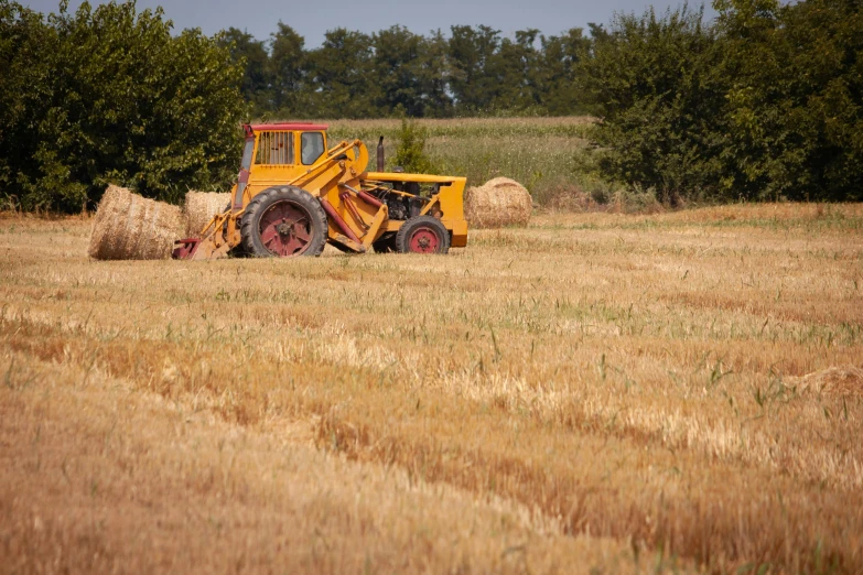 a tractor is being used to haul hay through the field