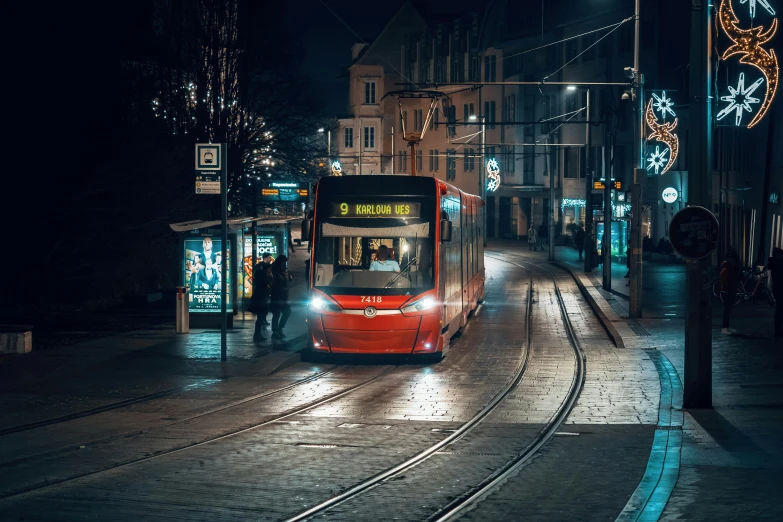 the city bus drives down the street during night