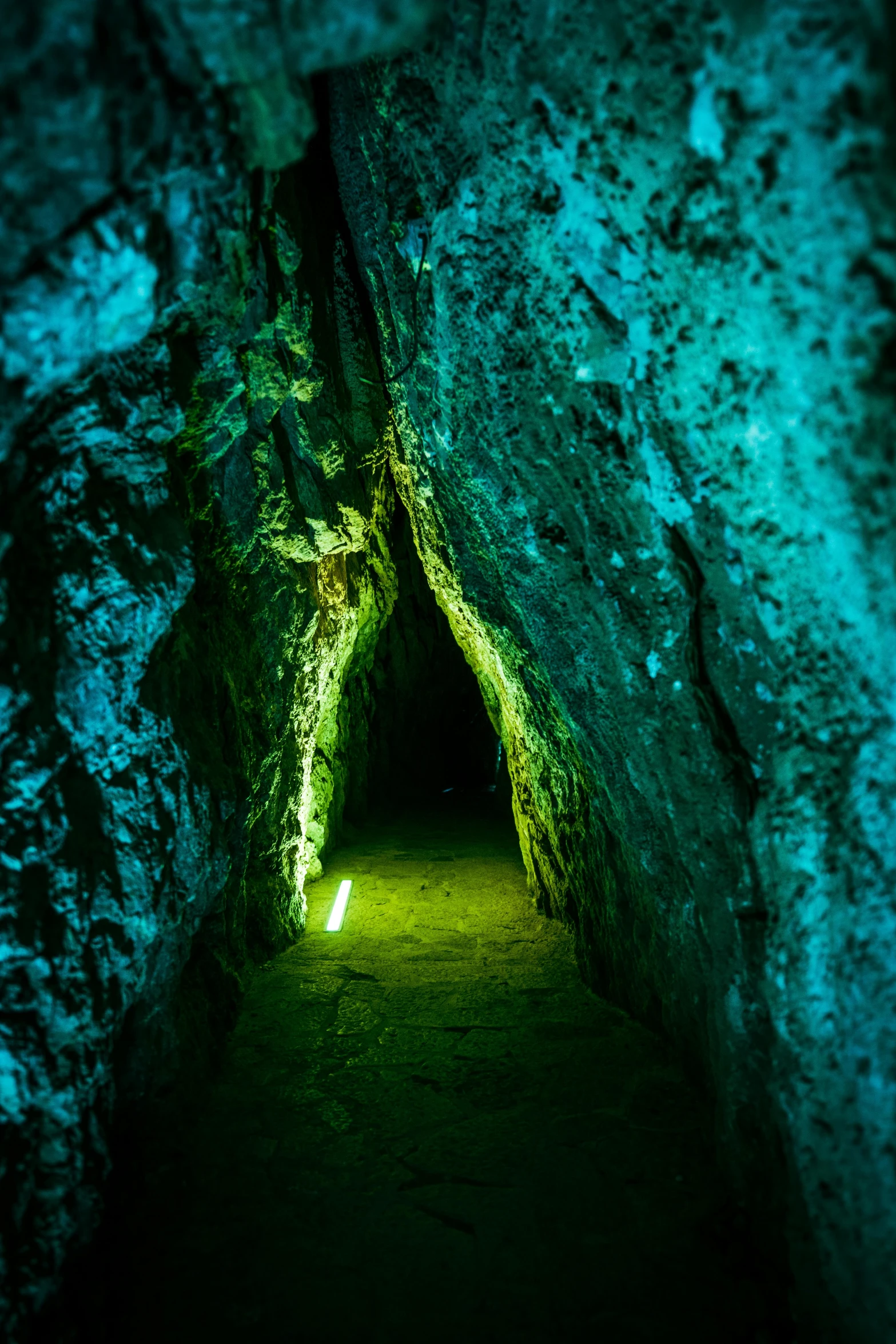 a small narrow tunnel is illuminated in green light