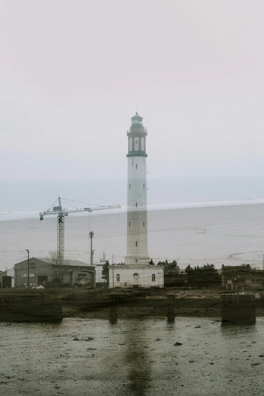 a tall light house sitting next to a body of water