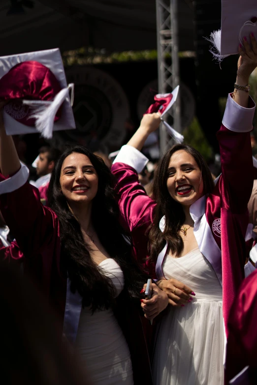 three girls dressed up in white and red holding up their hats