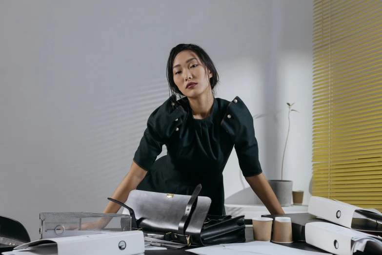 a woman with her eyes closed standing in front of office furniture