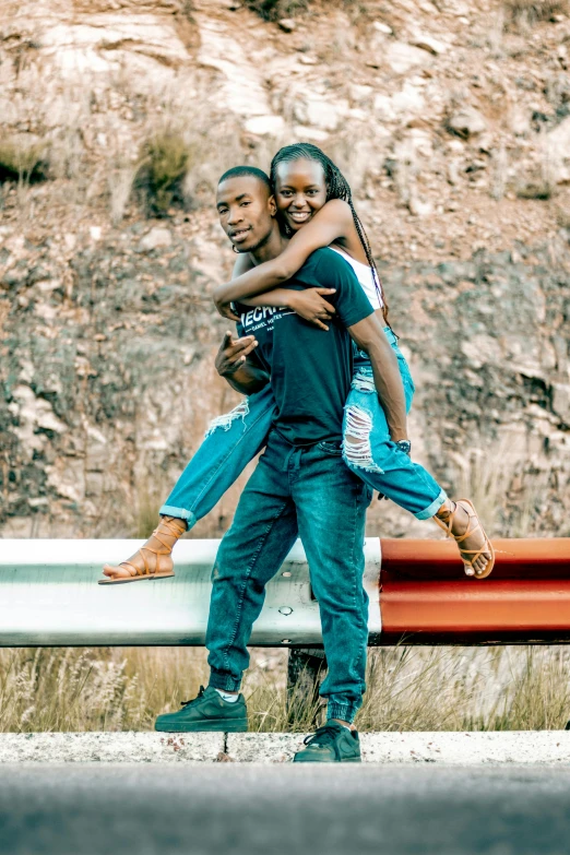 a couple hugging each other while standing near a road