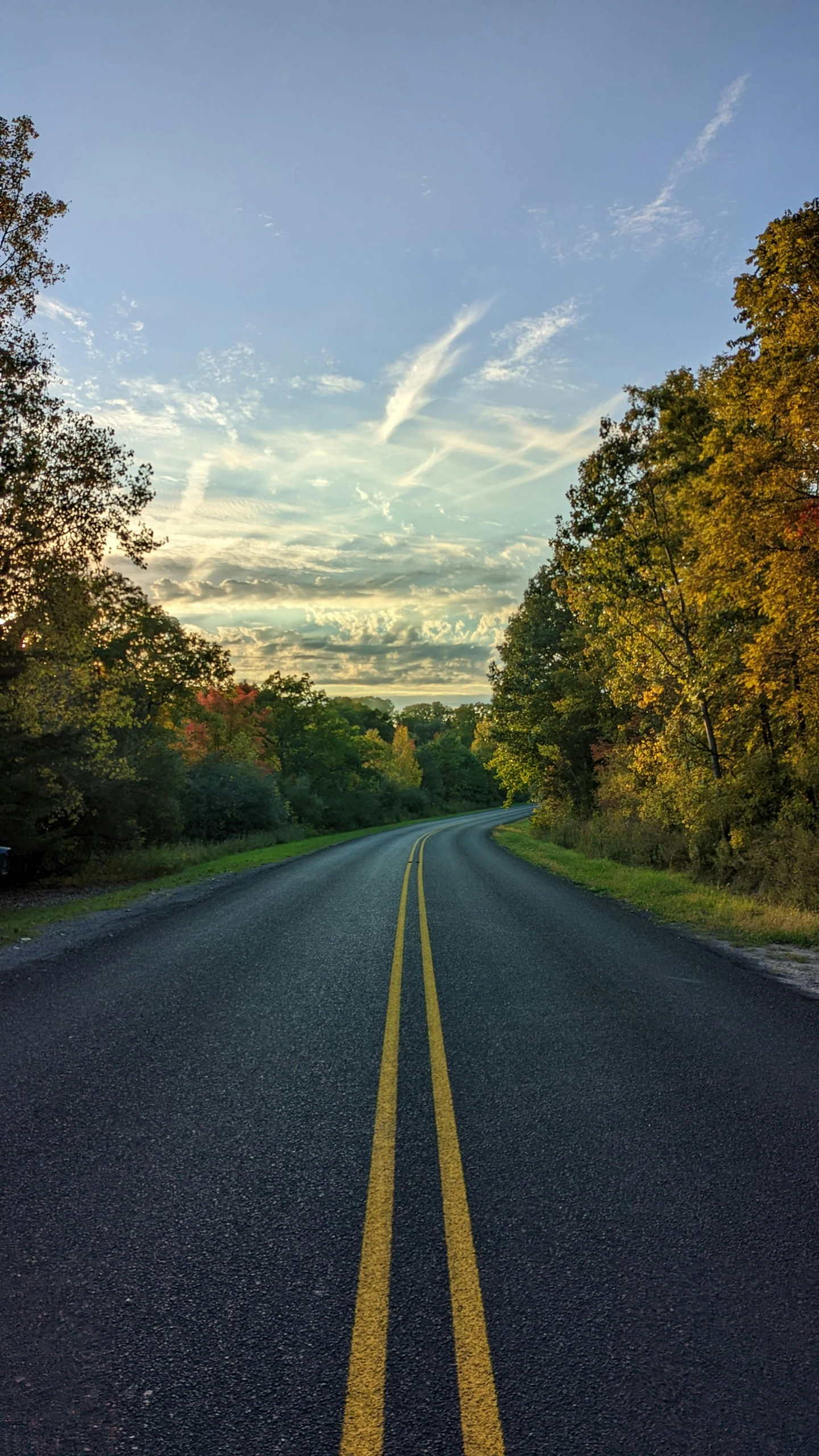 a long straight road is pictured in the evening