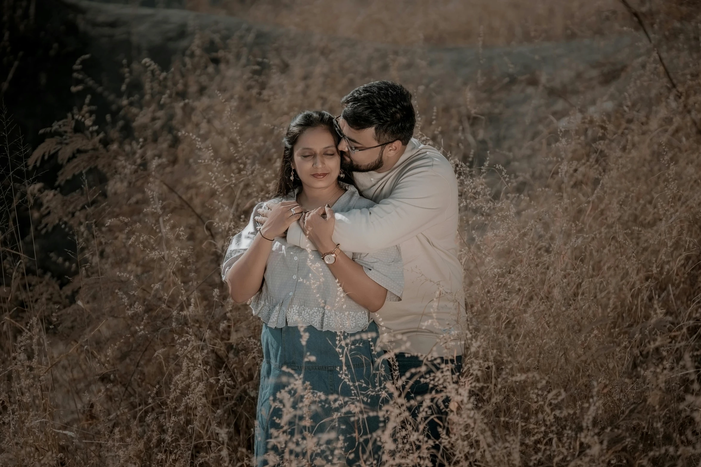 the newly married couple pose in tall grass