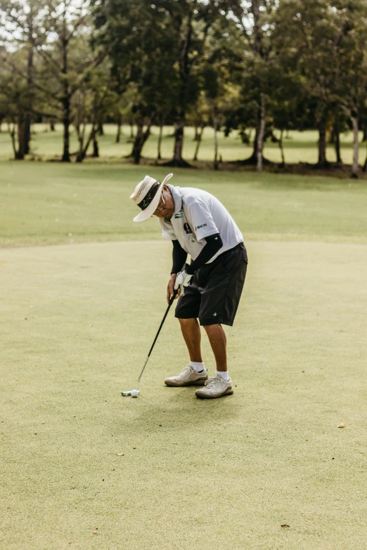 a man in golf clothes playing golf on the grass