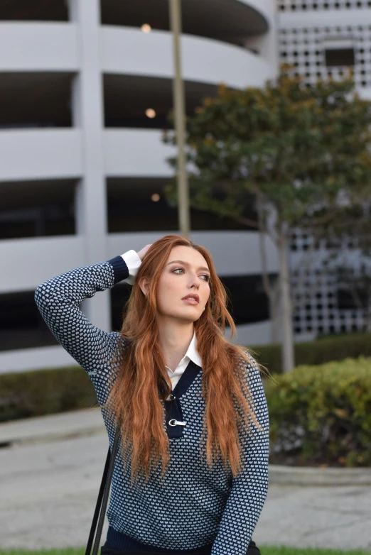 the woman is posing in front of a building