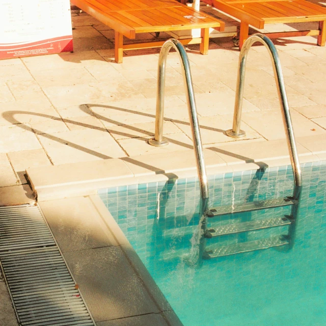 an outdoor pool is shown with a water slide and chairs