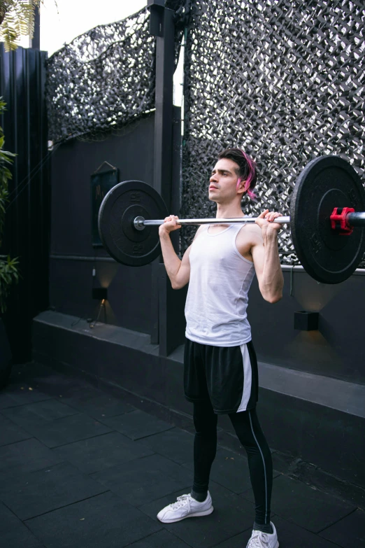 a man with pink hair lifts a barbell