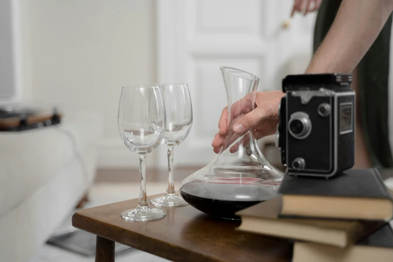 a person that is pouring some wine into wine glasses