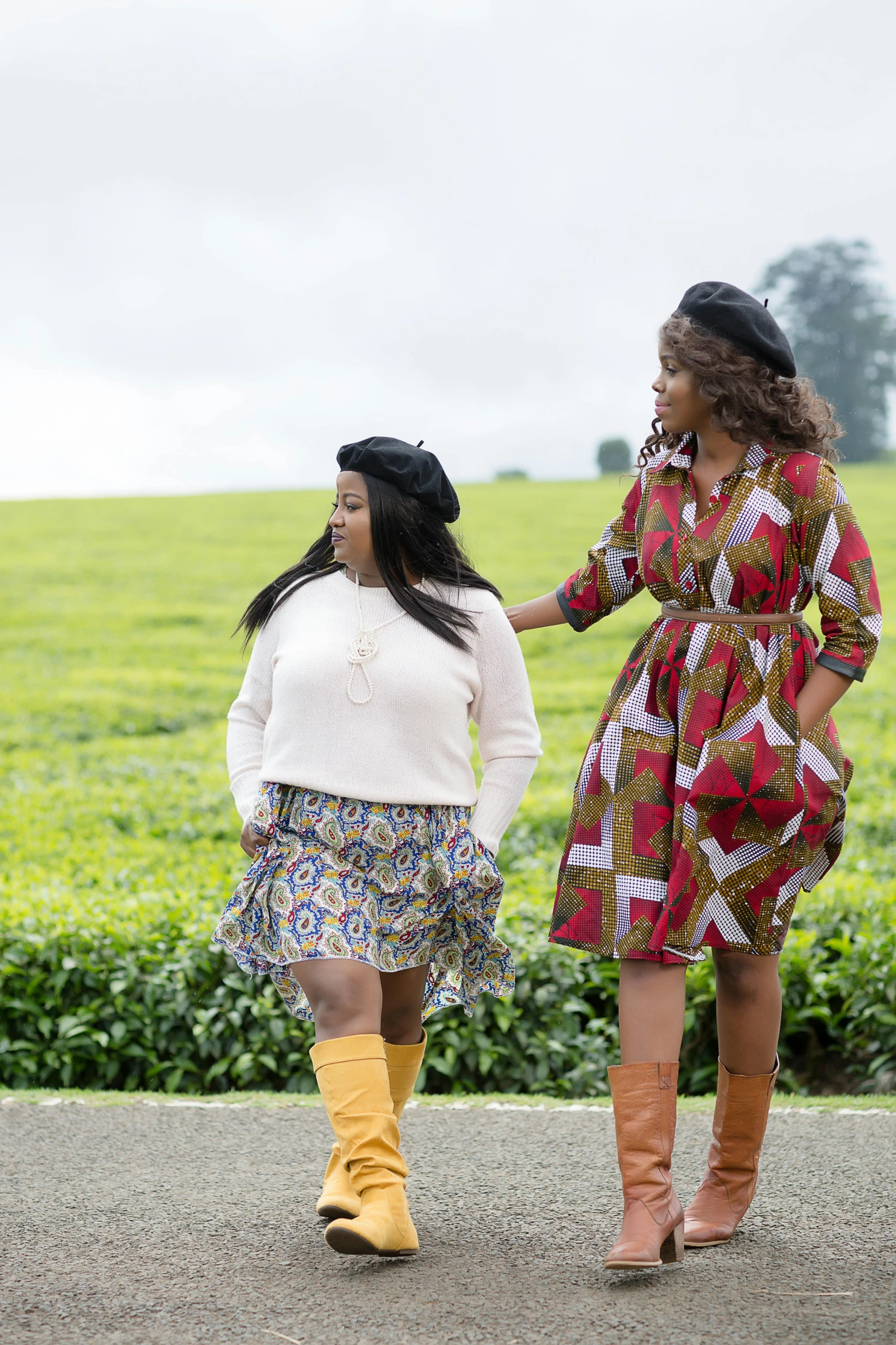 two women standing on a road talking on cell phones