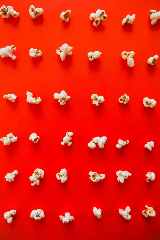 a red surface is covered with little pieces of popcorn