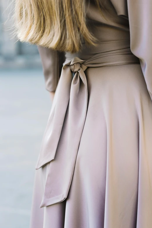 a woman with long blond hair wearing a brown dress