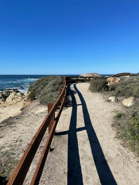 there is a long wooden fence by the beach