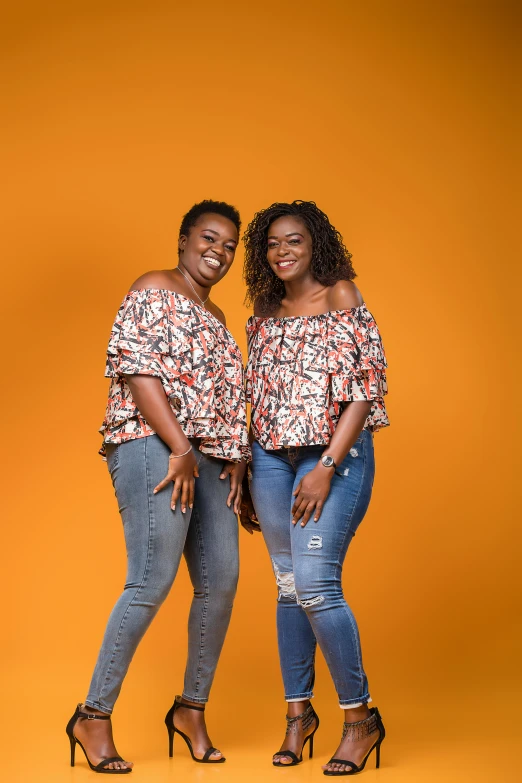 two black women standing together in jeans