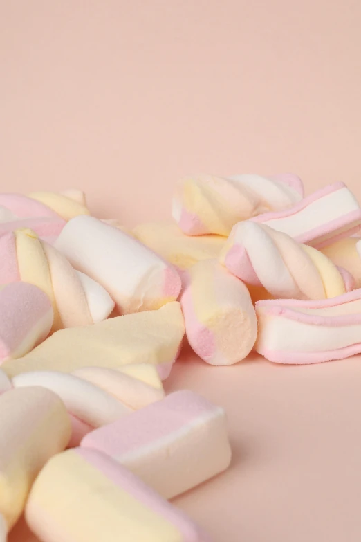 an assortment of marshmallows sitting on top of a pink surface