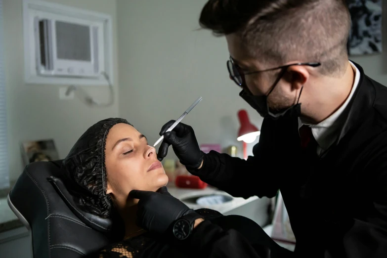 a woman is being given scissors by her barber