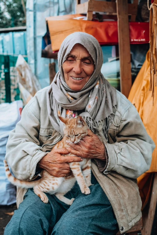 a woman sitting on the floor holding a cat