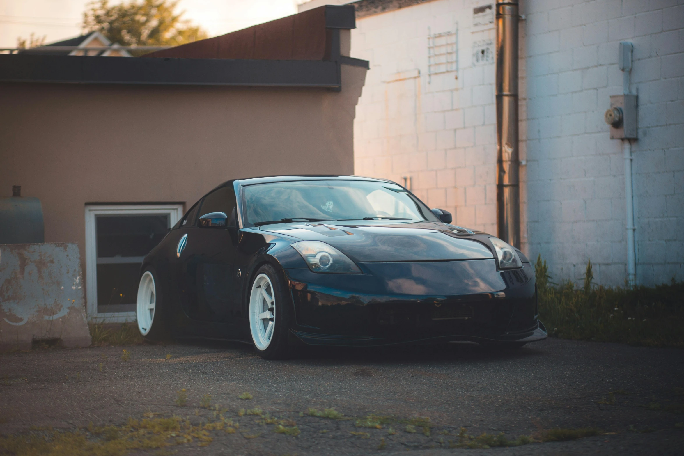 a black car parked in front of a brown house