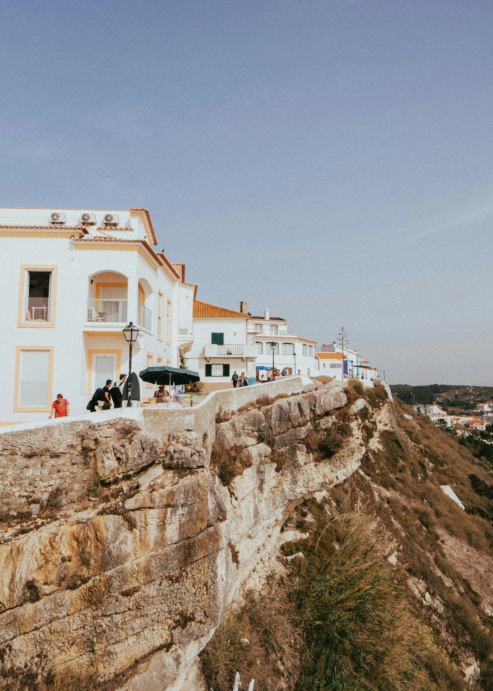 a large cliff side with cars parked along the edge