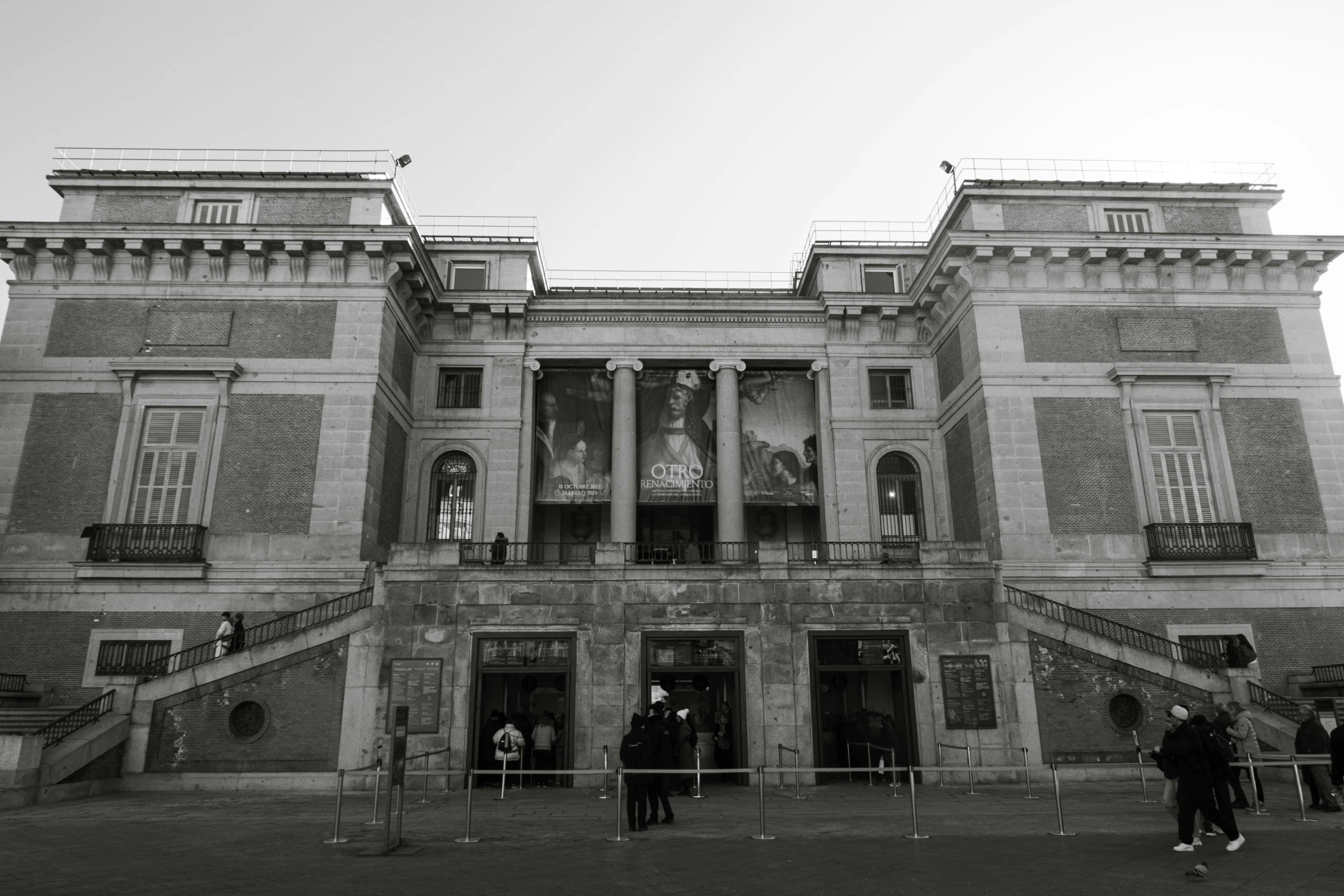 people standing outside a building with lots of stairs and windows