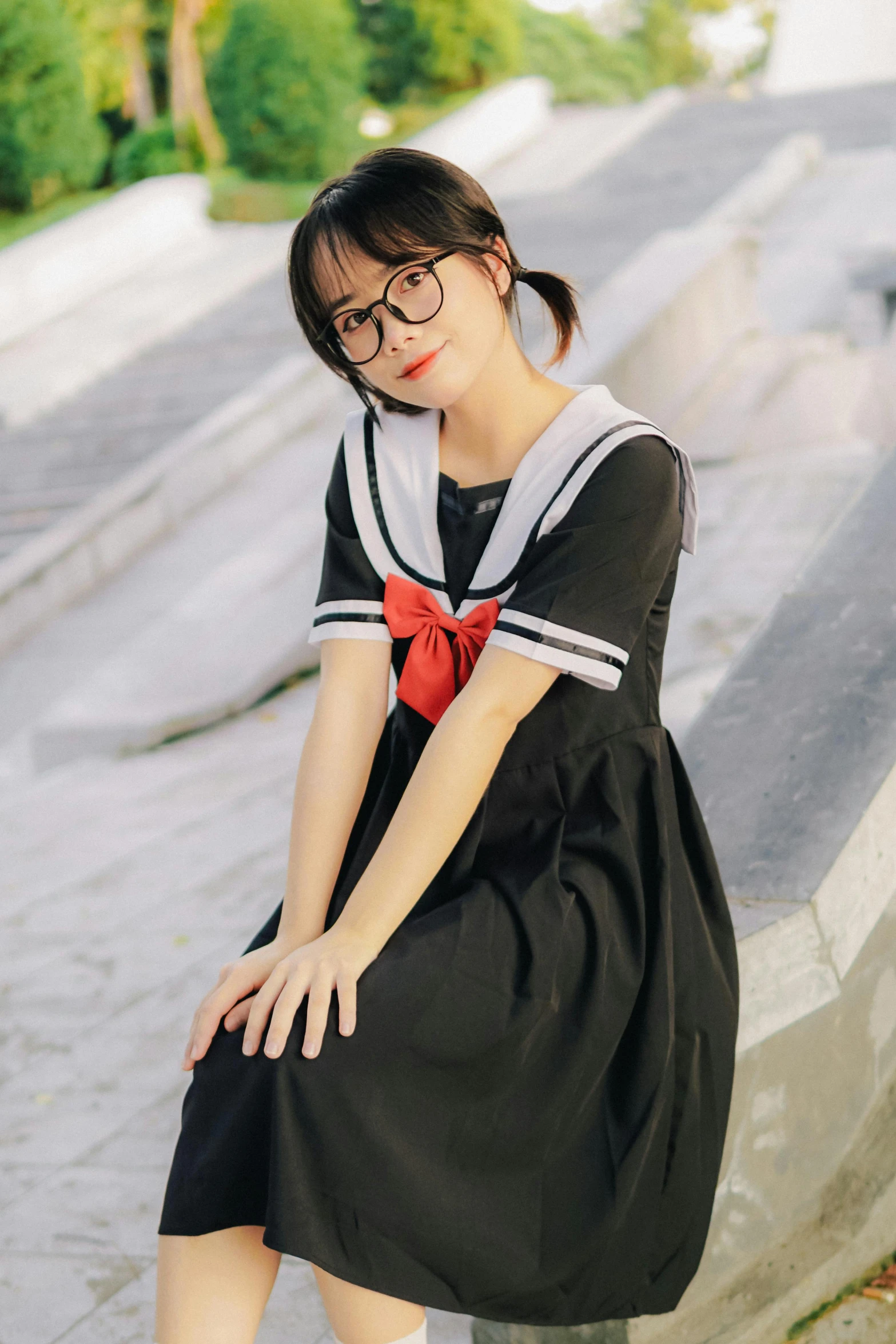 a woman sitting down near the steps of a park