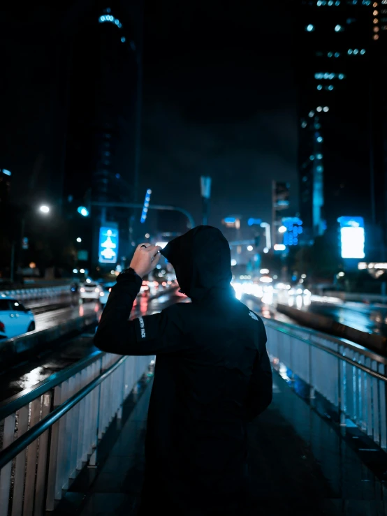 a person looking through a telescope in the city at night