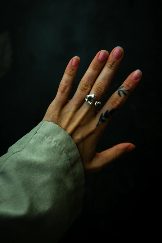 a hand with two rings with writing on it