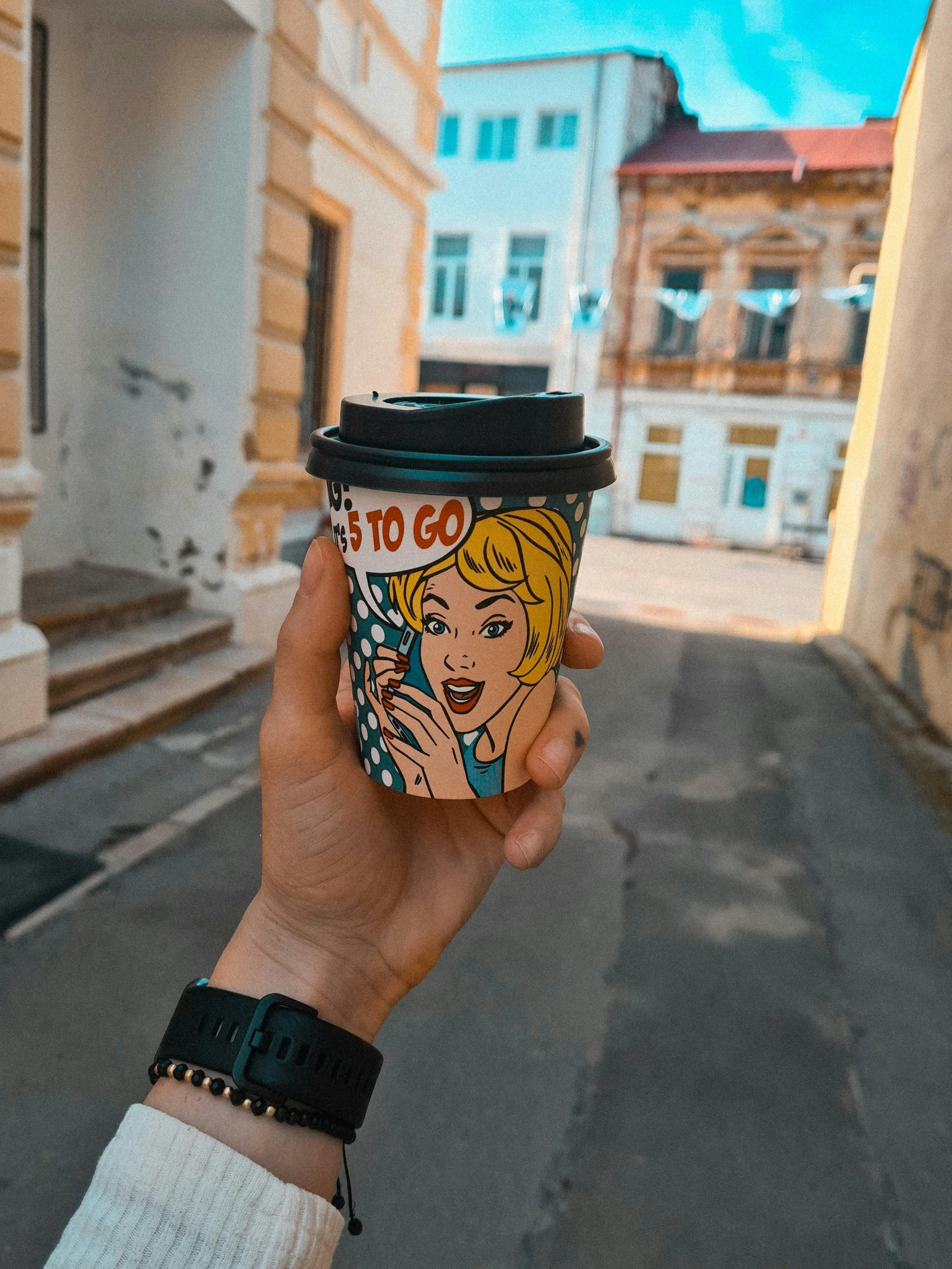 a hand holding a coffee cup of a woman