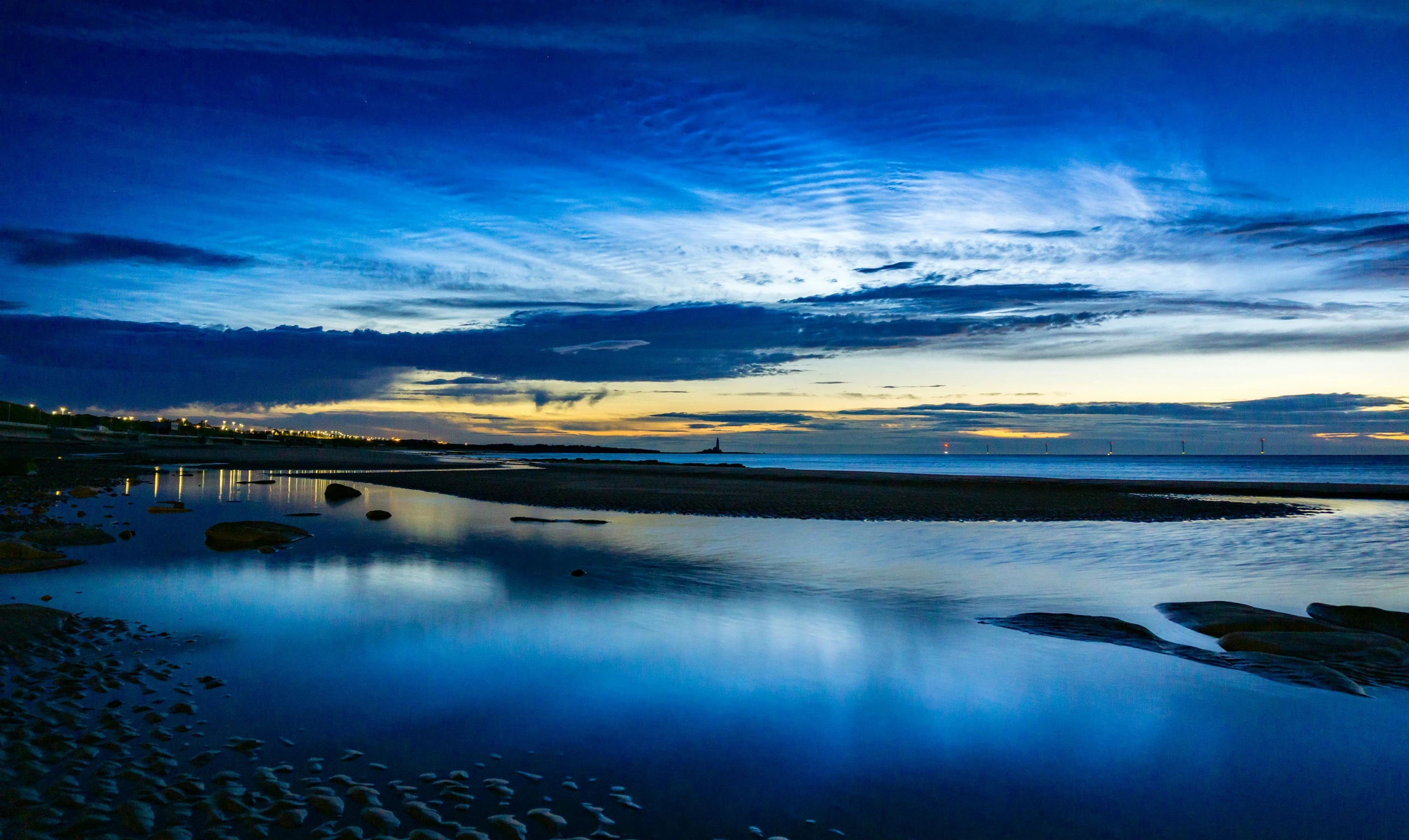 a very pretty blue sky with clouds by a river