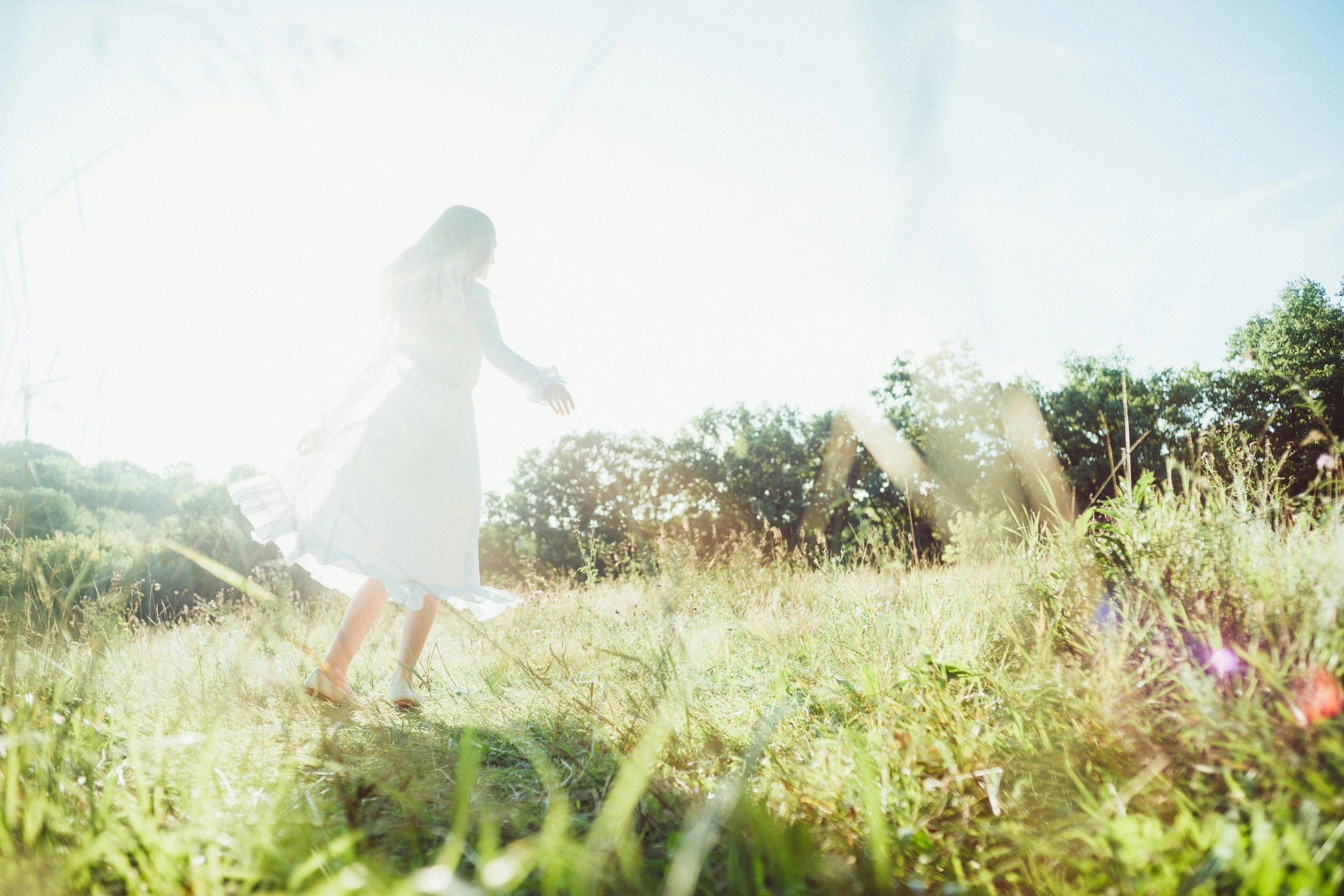 a girl walking in the grass during the day