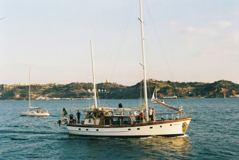 people stand on the front end of a sailboat