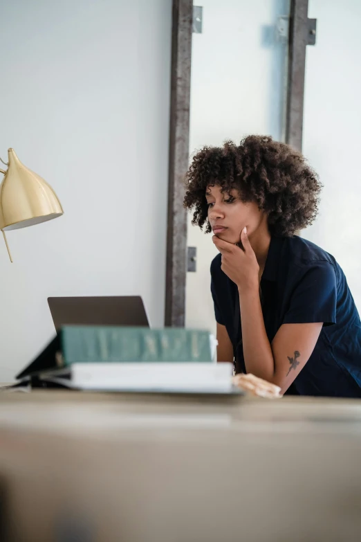 a woman in a black shirt using her laptop