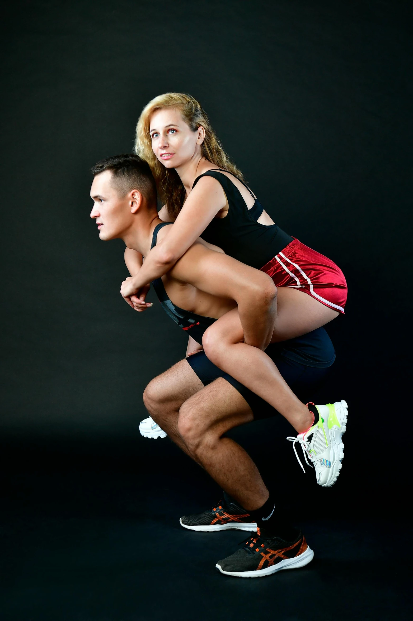 two young, athletic people with a black background