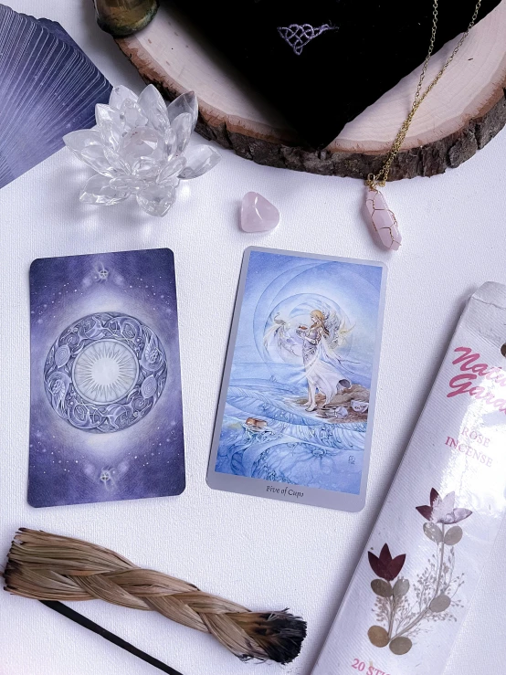 three cards with crystals, a pen, and a book on it