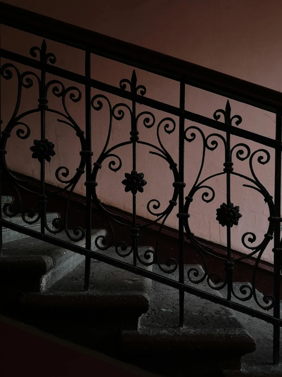 a stairway with railing with black iron fence