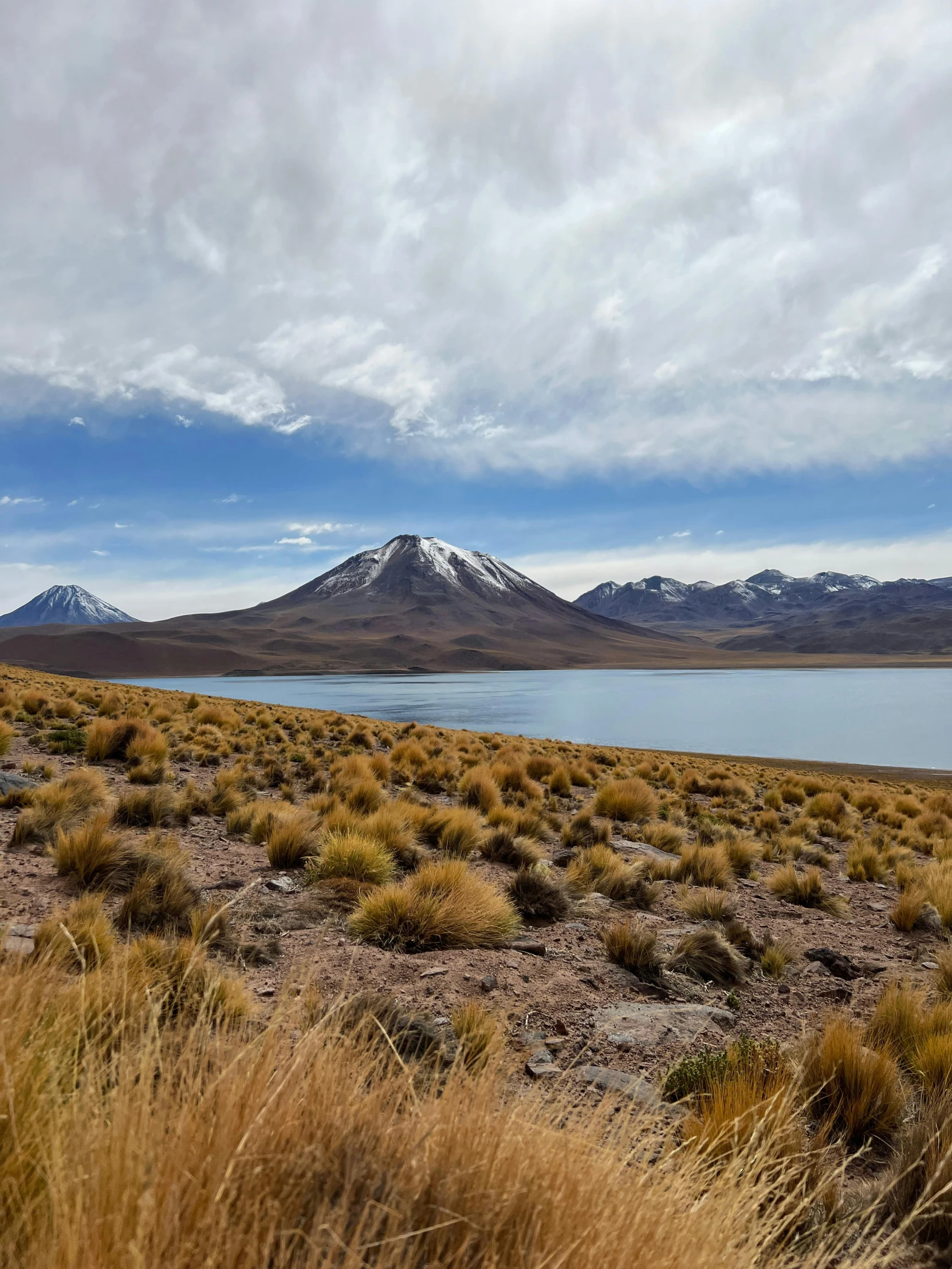 water in the desert under clouds, with a few small mountains