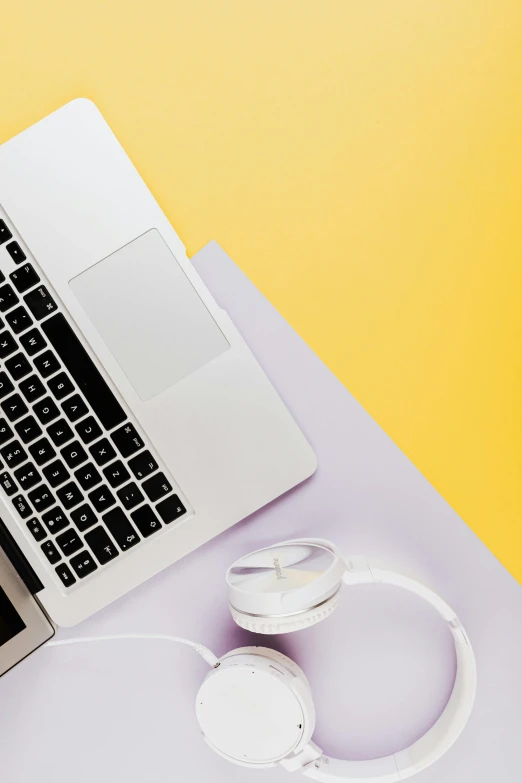 a laptop, headphones and another laptop on a desk