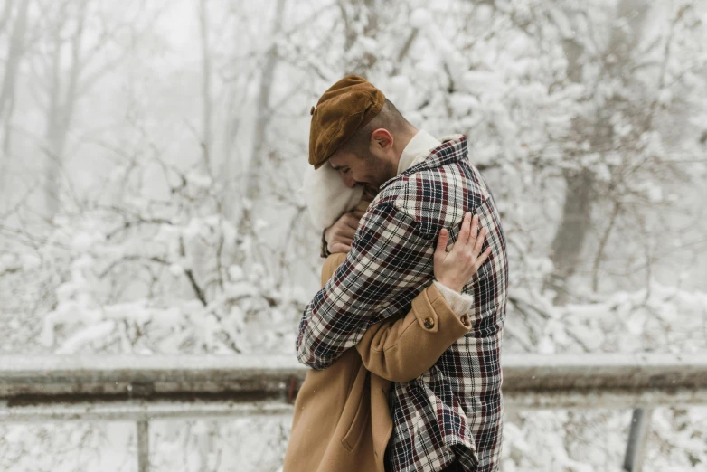 a man in winter clothing is hugging another