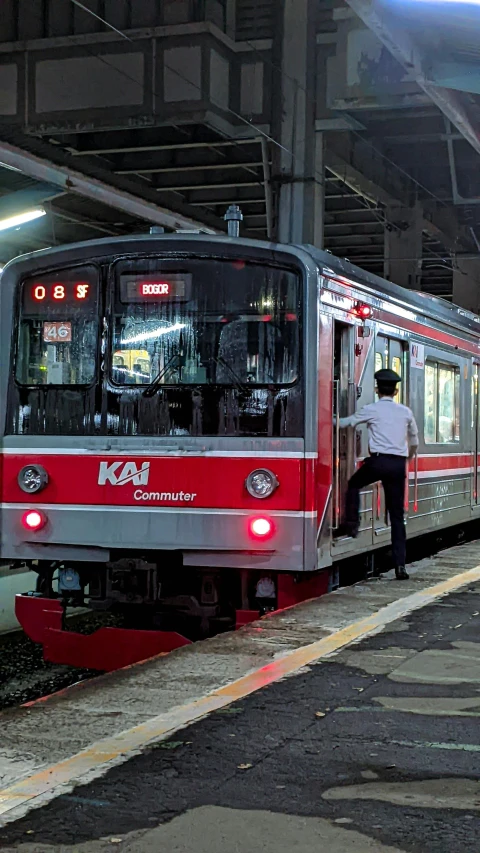 a man stands at the edge of a platform as a train arrives