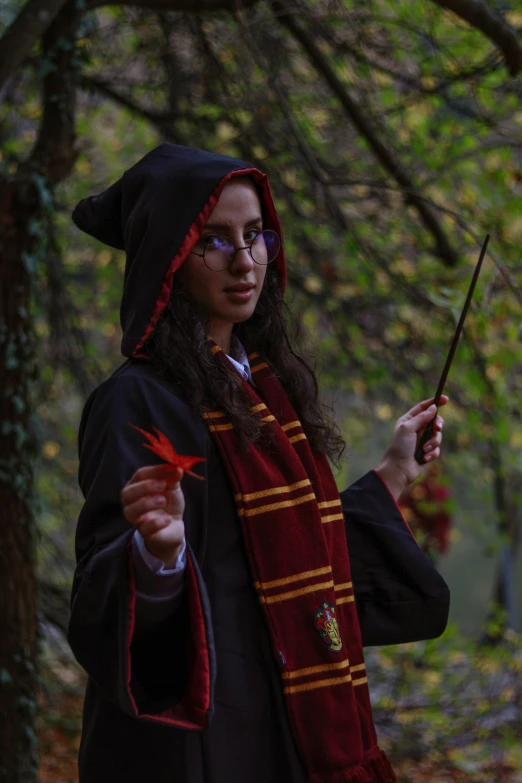 a woman in a harry potter outfit holding a wand