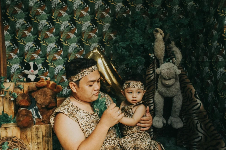 a man holding a child wearing some art nouveau outfits