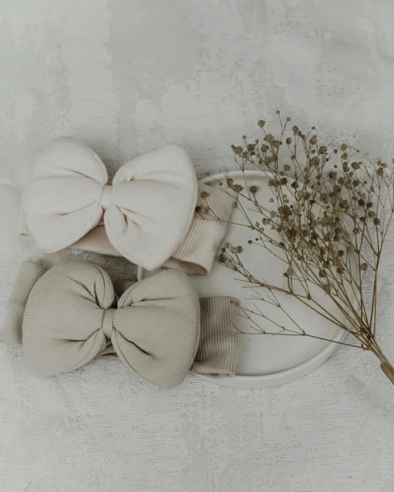 several white and brown bow - tied items are arranged on a plate