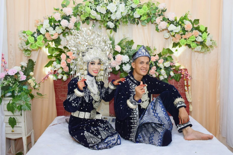 two women are sitting in front of an elaborate archway