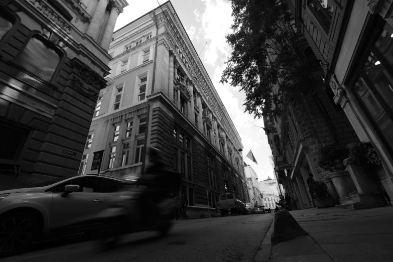 some buildings a car a street and a tree