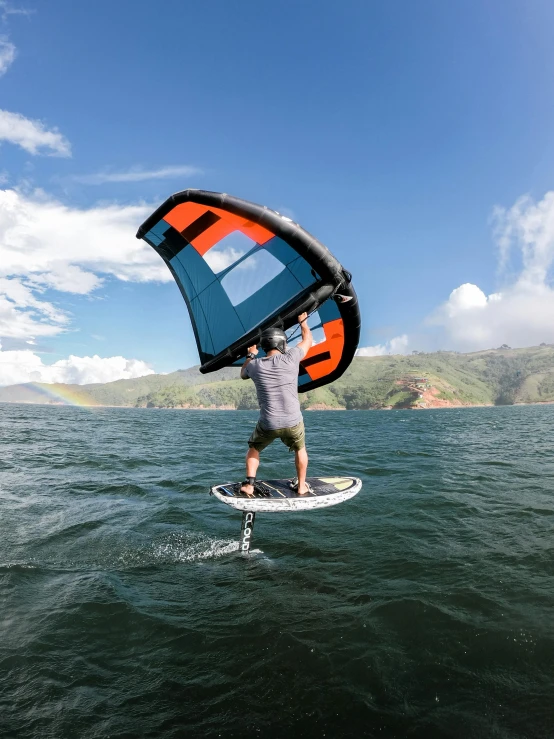 a man is holding the sail board above water