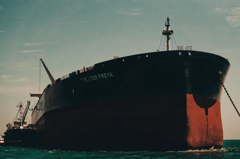 a ship floating in the ocean with another boat nearby