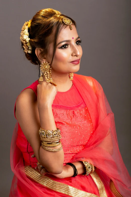 a woman in a sari, with jewelry on her neck and head