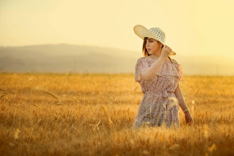 a woman in a dress standing in an open field