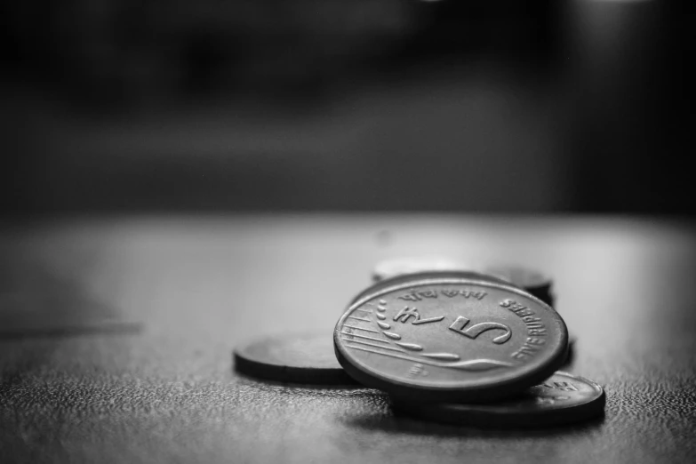 two coins sitting on top of a wooden table
